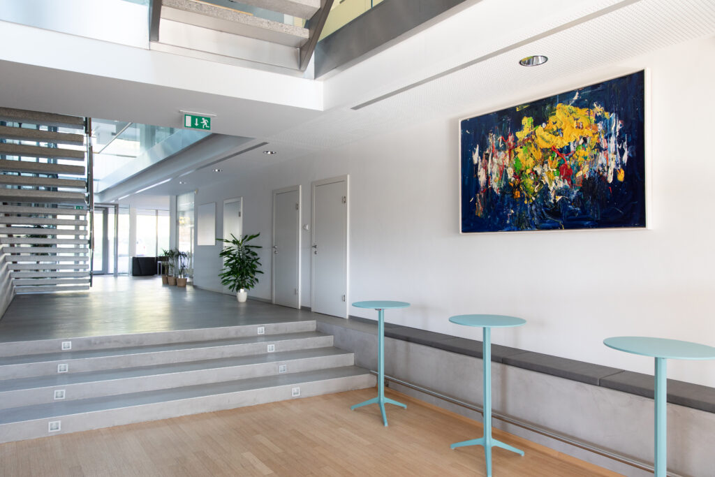 Gebäude, Bild und Tische blau, graue Stiegen